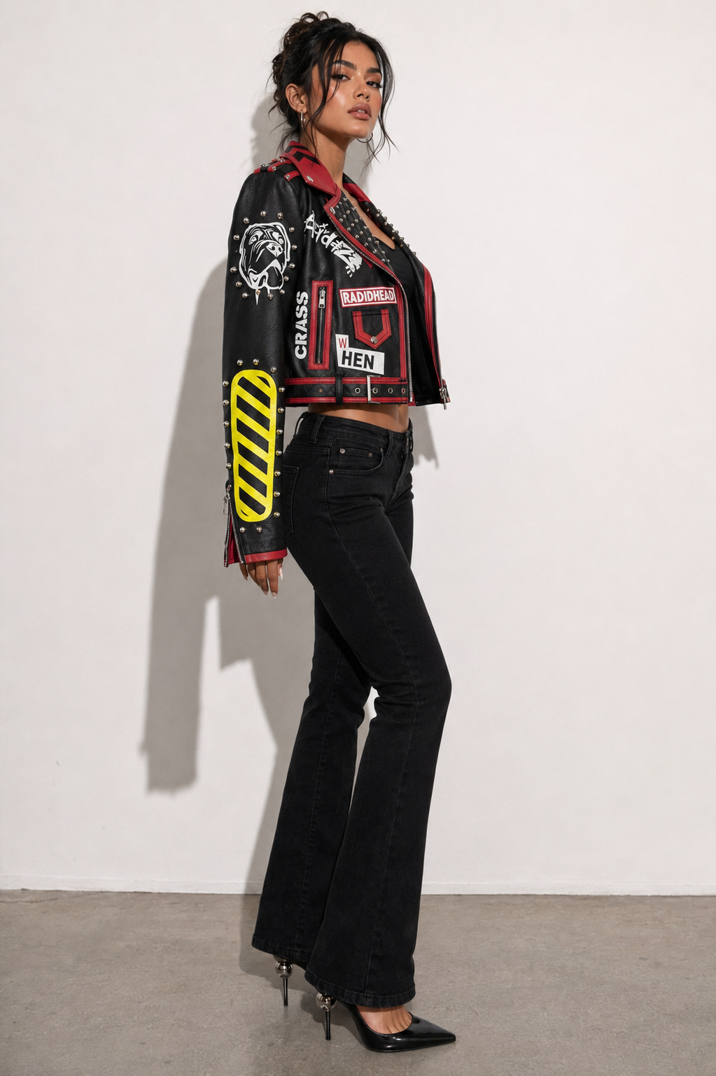 Model wearing black and red moto faux leather jacket, side view highlighting graphic paneling and urban moto-inspired design by For Her NYC