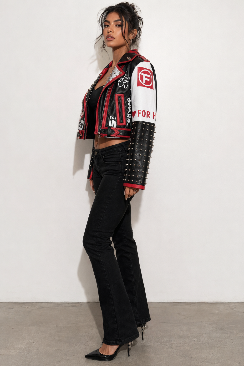 Model wearing black and red moto faux leather jacket, side view highlighting graphic paneling and urban moto-inspired design by For Her NYC