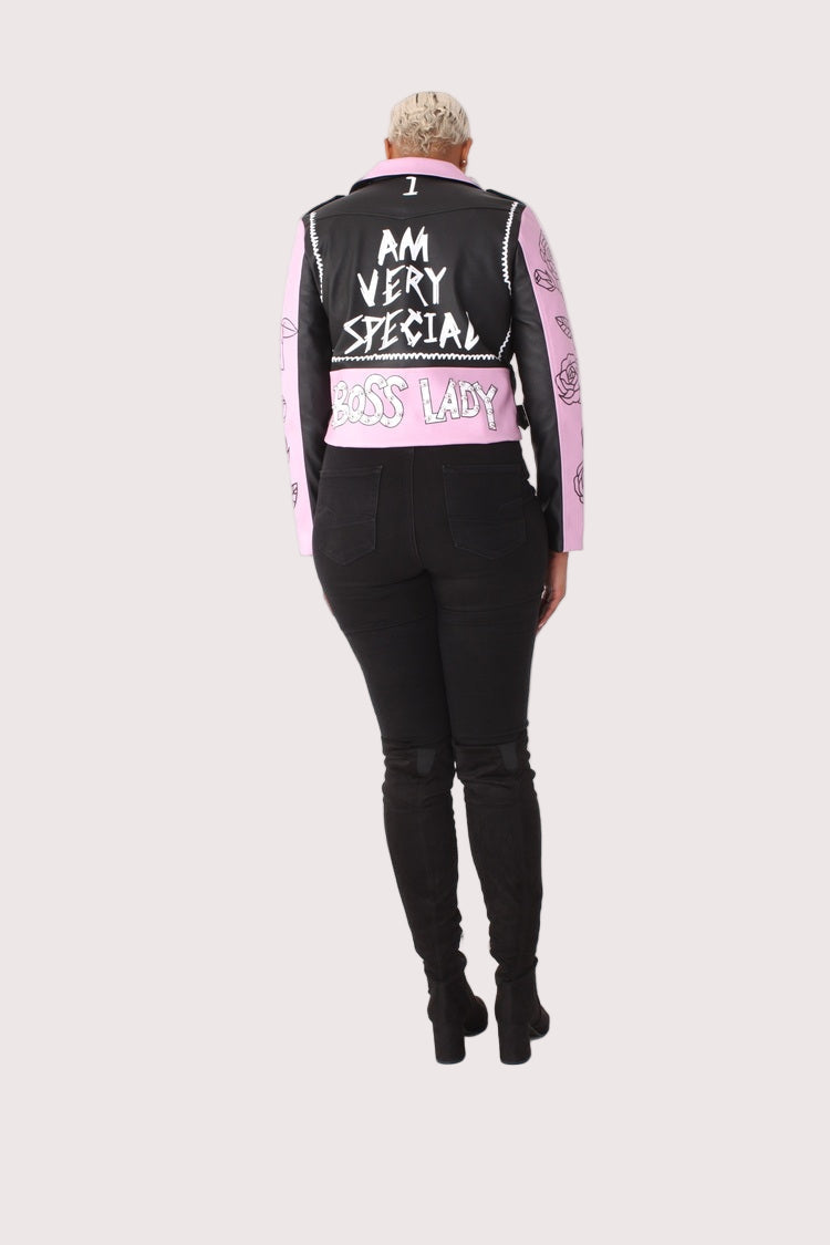 Model wearing LILAC /BLACK faux leather jacket with pins and studs, full back view highlighting positive message graphic on back by For Her NYC