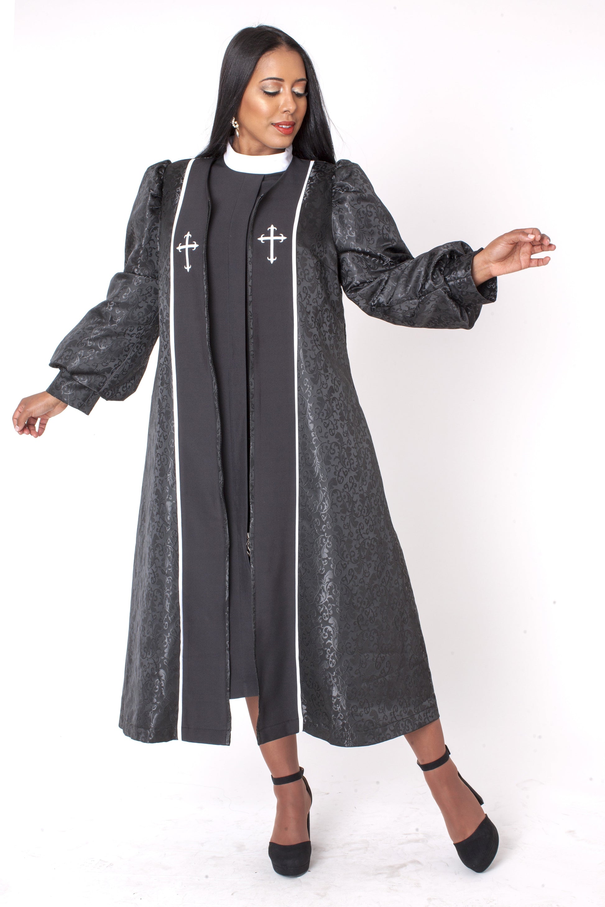 Plus size black brocade clergy robe with cross detail, model standing with arms slightly out — Tally Taylor