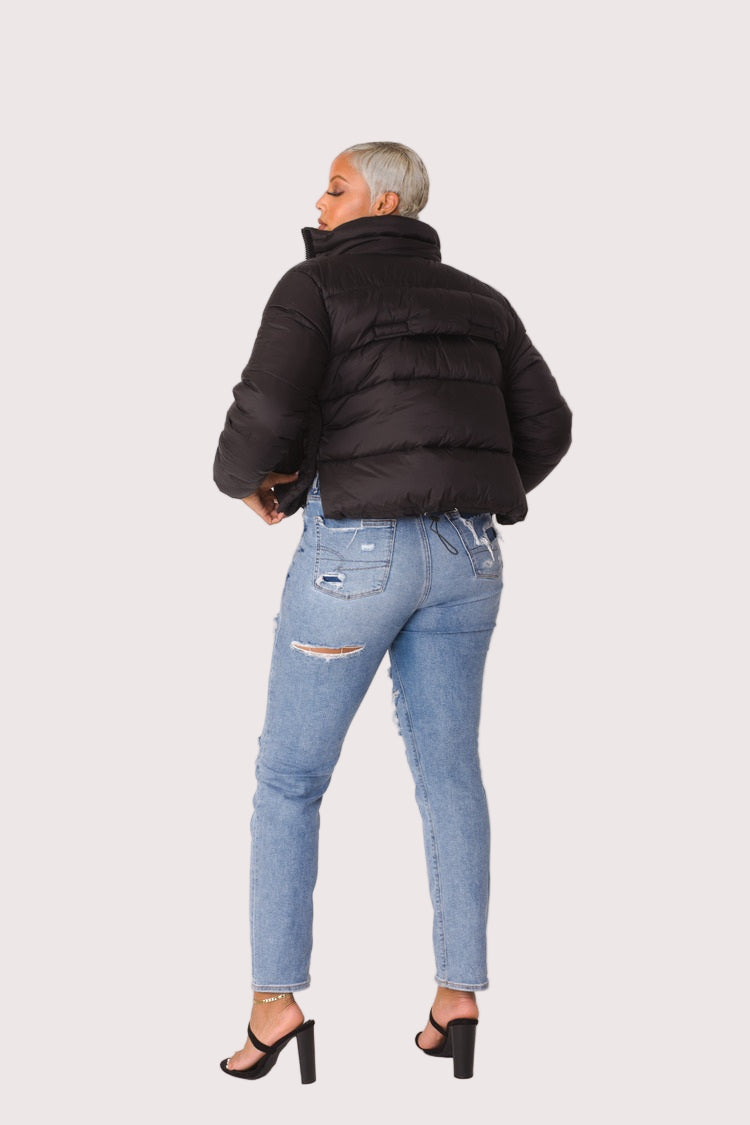 Model wearing black plush puffer jacket, back view highlighting padded construction, oversized fit, and full faux fur texture by For Her NYC