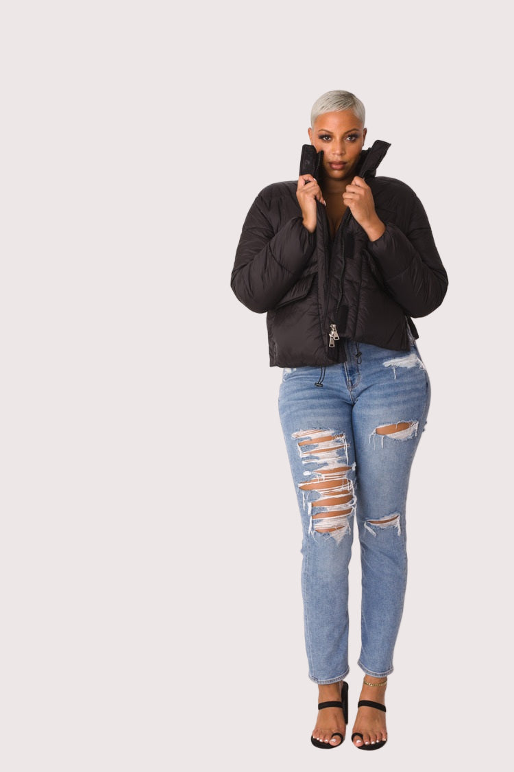 Model wearing black plush puffer jacket, front-facing hero pose highlighting faux fur texture, oversized silhouette, and zip-up closure by For Her NYC