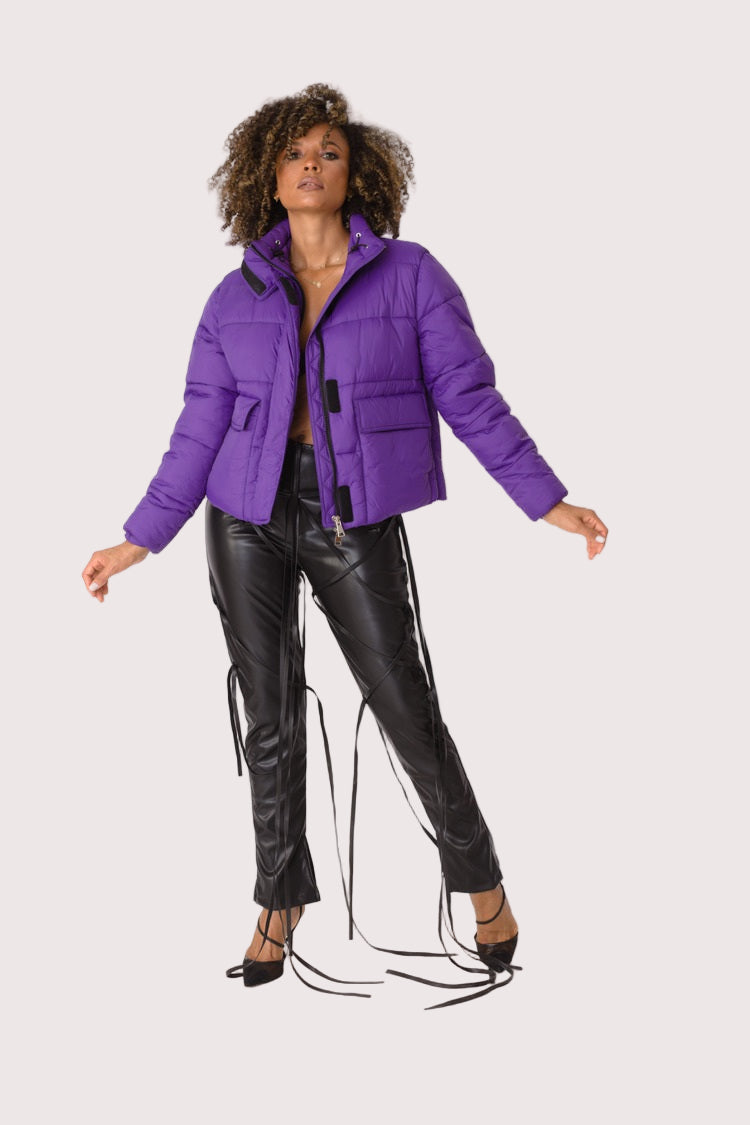Model wearing purple plush puffer jacket, front walking pose showcasing casual movement, padded warmth, and statement color by For Her NYC