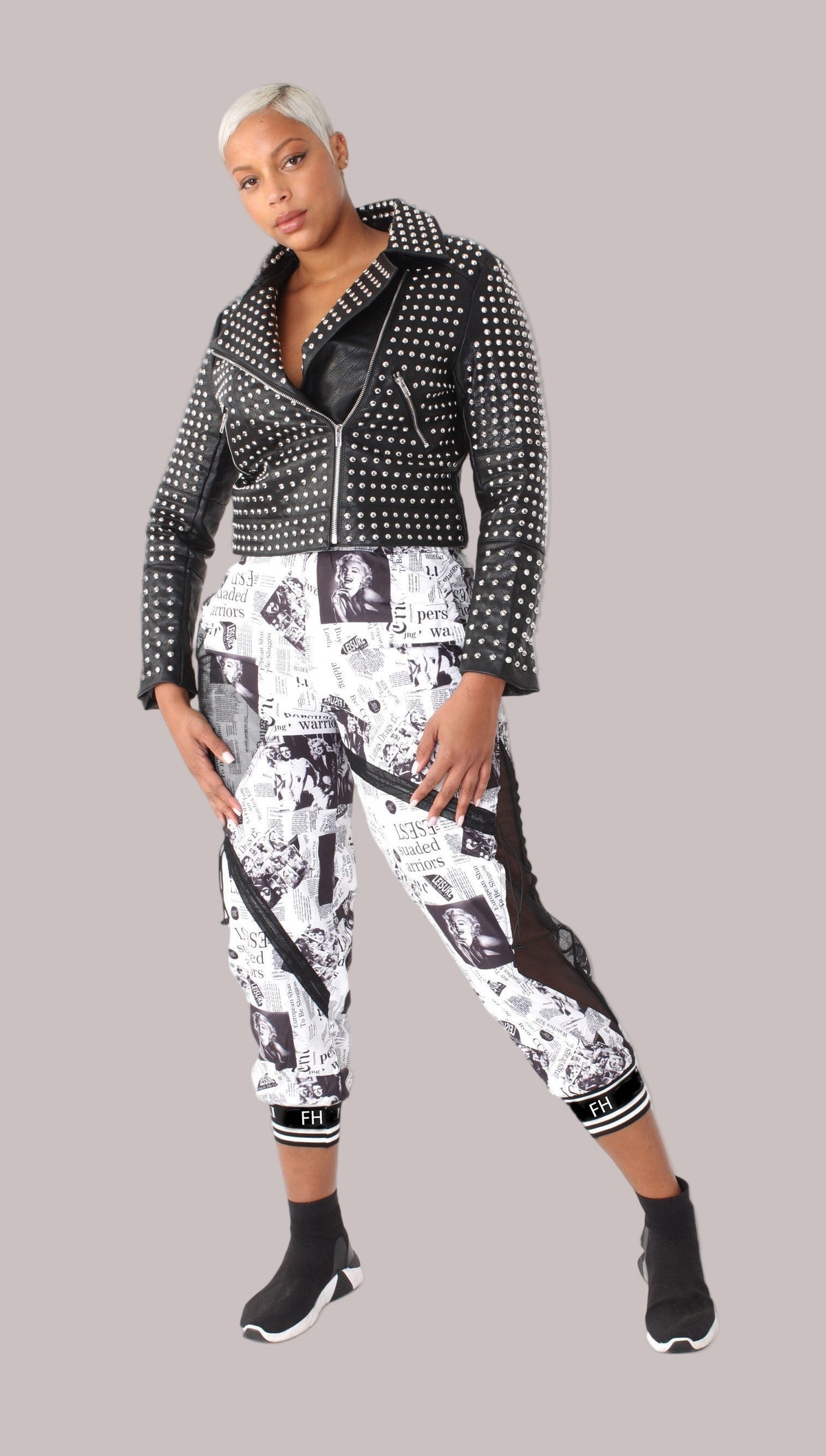 front view of printed mesh patchwork joggers styled with studded moto jacket