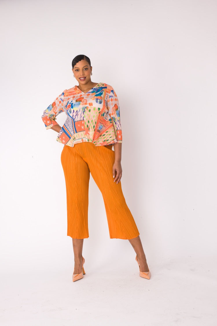 Front step pose of a printed top and palazzo pants set in orange multi, highlighting movement and wide-leg palazzo fit by For Her NYC