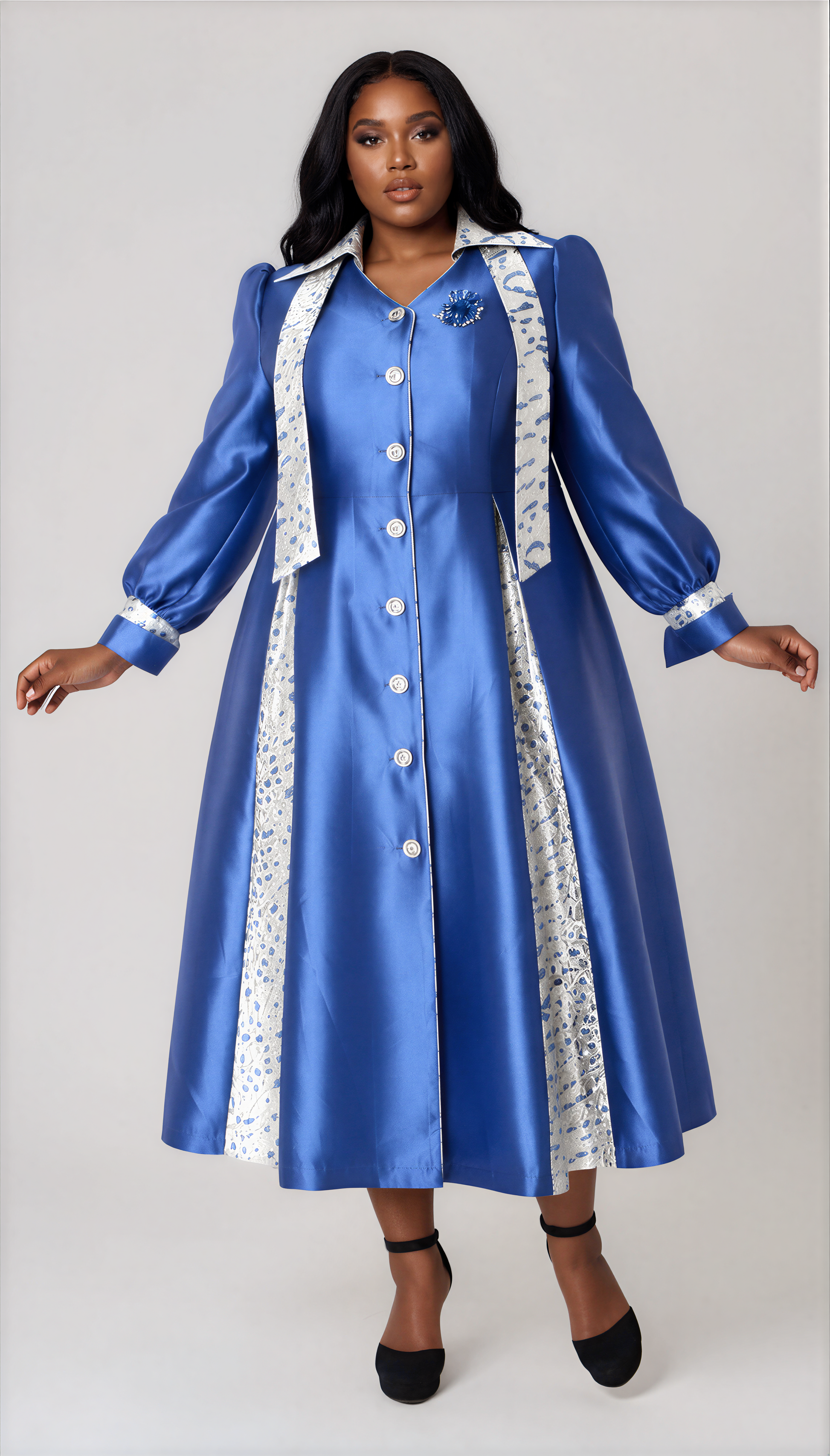 Plus size model wearing the Tally Taylor Contrast Panel Clergy Robe in Royal Blue, featuring elegant contrast panels, a flattering A-line silhouette, button-front design, flowing puff sleeves, and refined tailoring for worship services, Women's Day celebrations, choir presentations, communion ceremonies, church anniversaries, and ministry events.