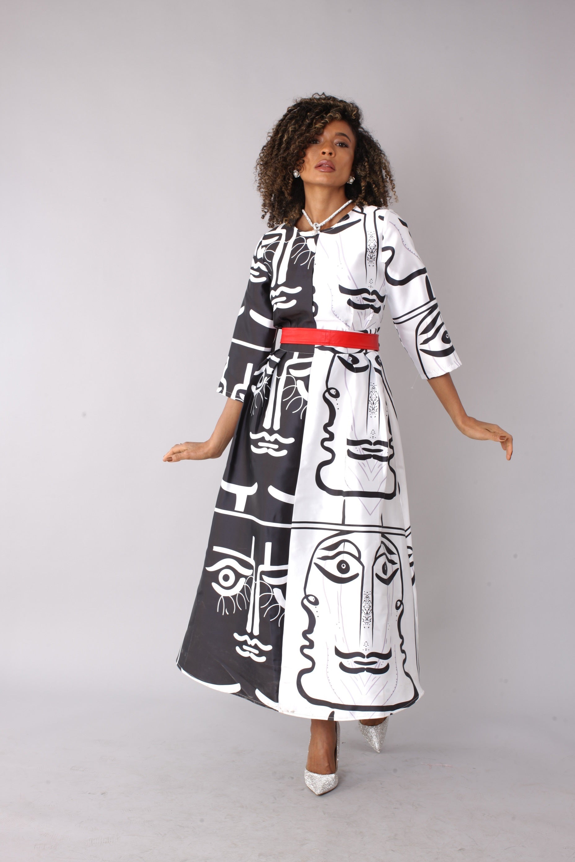 White satin dress with black graphic print and rhinestone brooch, model standing front pose – Tally Taylor