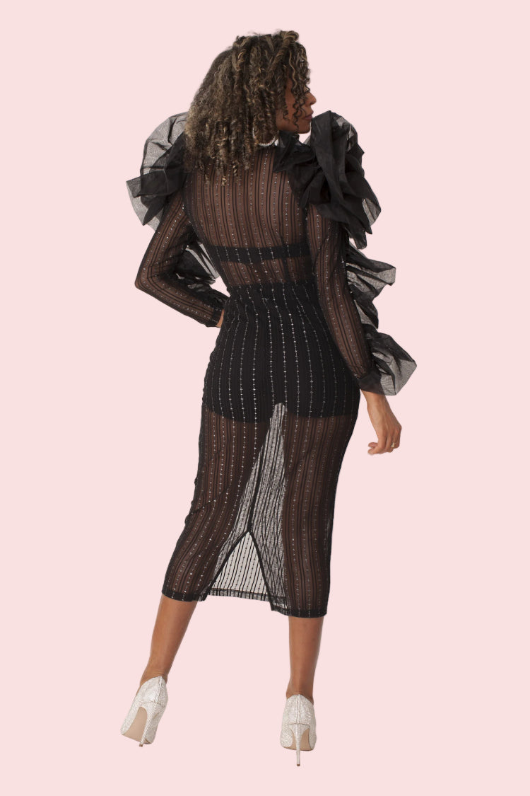 Model wearing black sheer ruffled midi dress shown from the back view with dramatic ruffle sleeves and fitted silhouette detail. For Her NYC