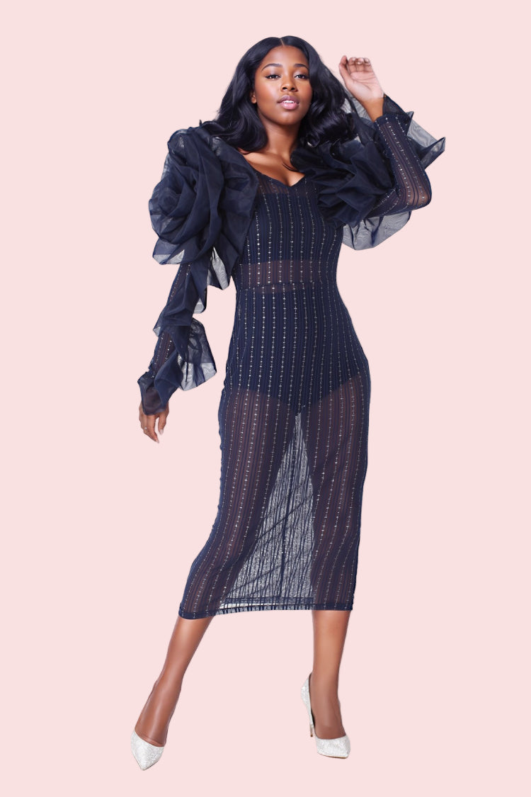 Model wearing navy sheer ruffled midi dress in full front pose with bold ruffled sleeves and modern fitted shape. For Her NYC