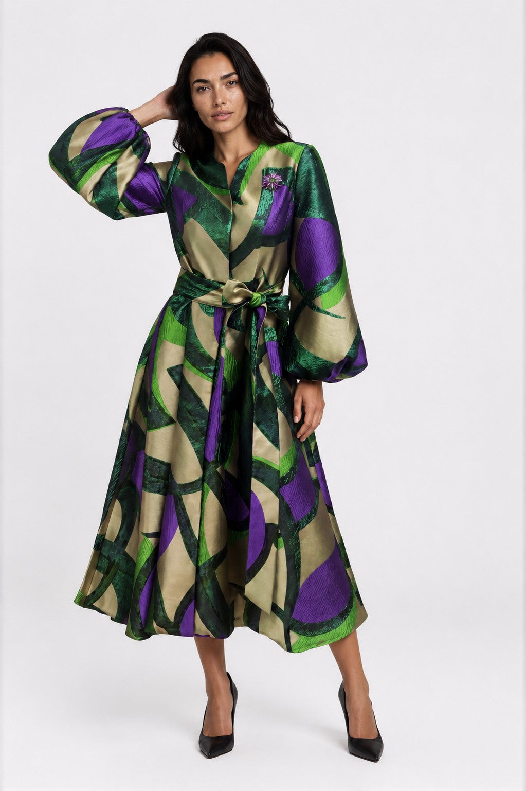 Model posing in the Spring Blossom A-Line Dress in Green Multi with a bold floral print, belted waist, dramatic long sleeves, and an elegant A-line silhouette by Tally Taylor.