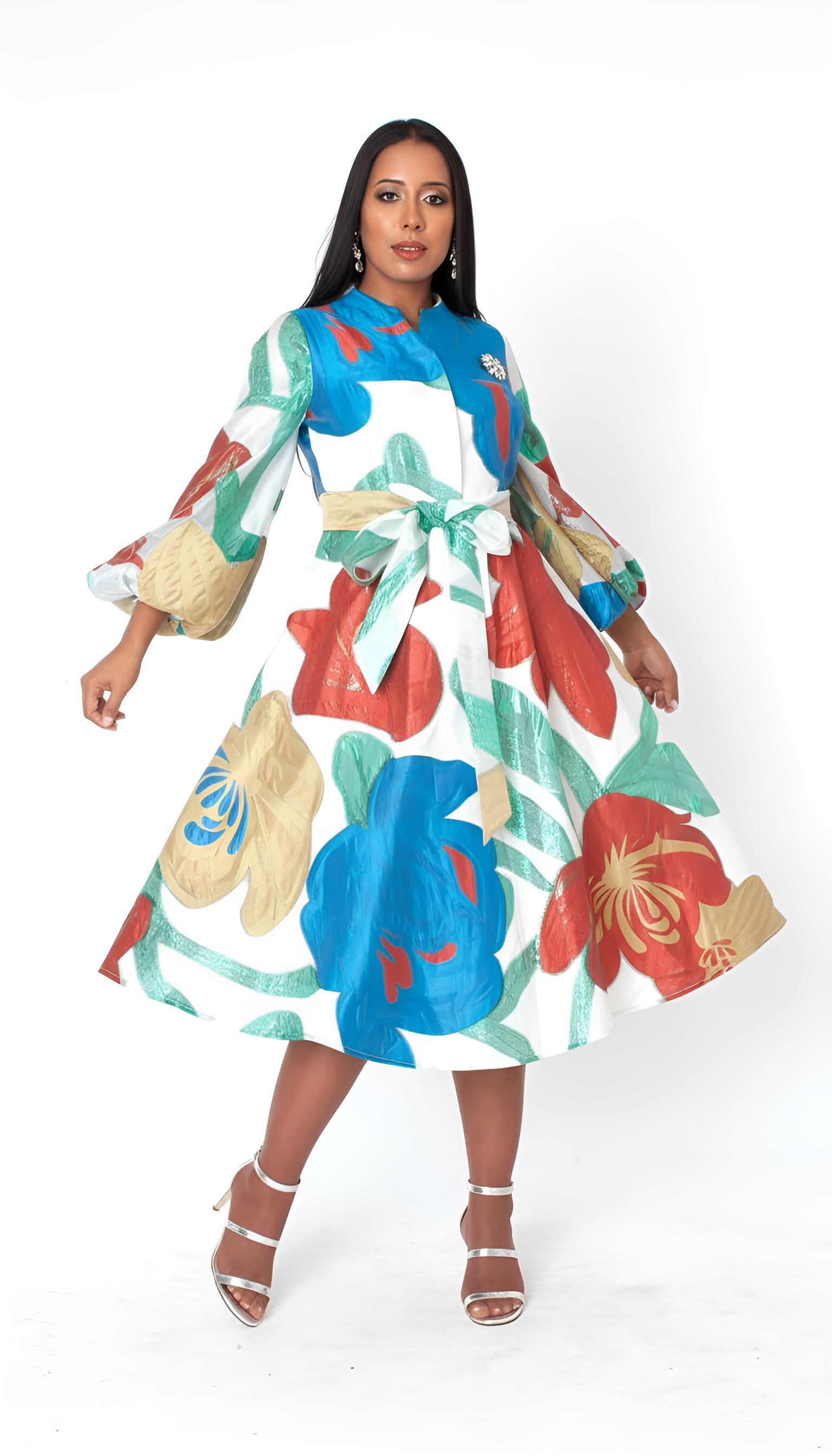 Model wearing the multi spring blossom a line dress standing front facing, showcasing bold floral print, belted waist, and flowing A line silhouette by Tally Taylor