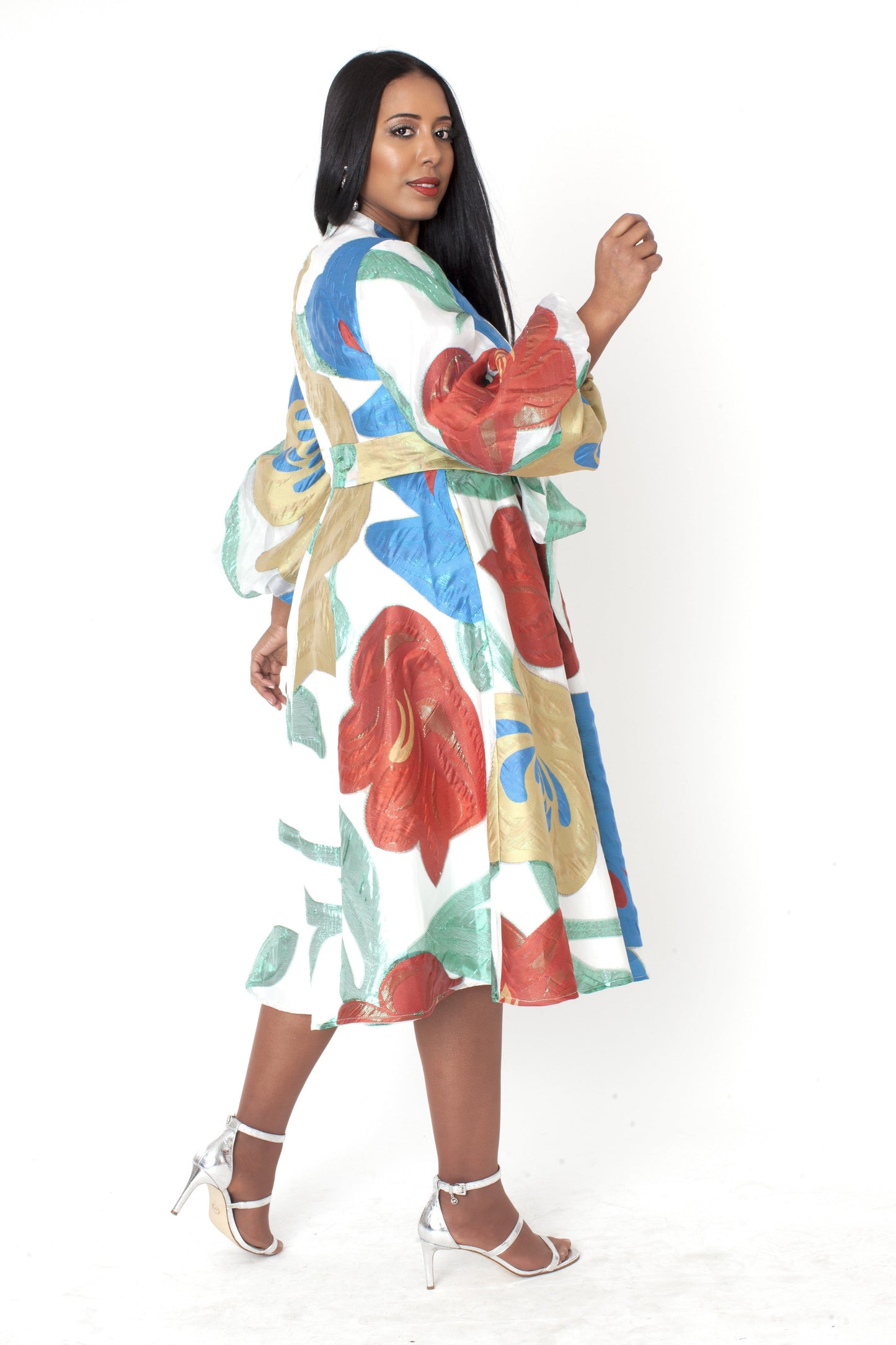 Model wearing the multi spring blossom a line dress walking forward, highlighting elegant movement, vibrant floral artistry, and polished midi length by Tally Taylor