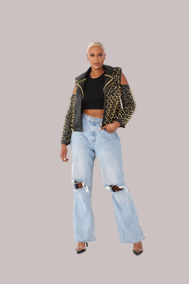 Black/gold studded pleather moto jacket with open shoulder design, front standing pose styled with light denim by For Her NYC