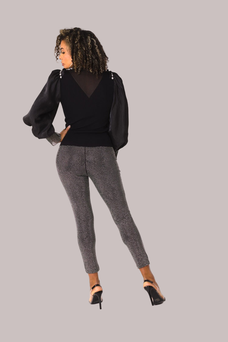 Rear angled view of black suede diamond embellished pants with crossed leg pose – For Her NYC
