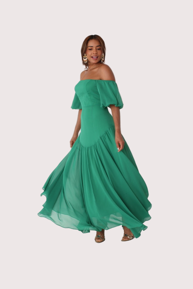 Emerald off-shoulder maxi dress shown on model walking forward with flowing movement, For Her NYC