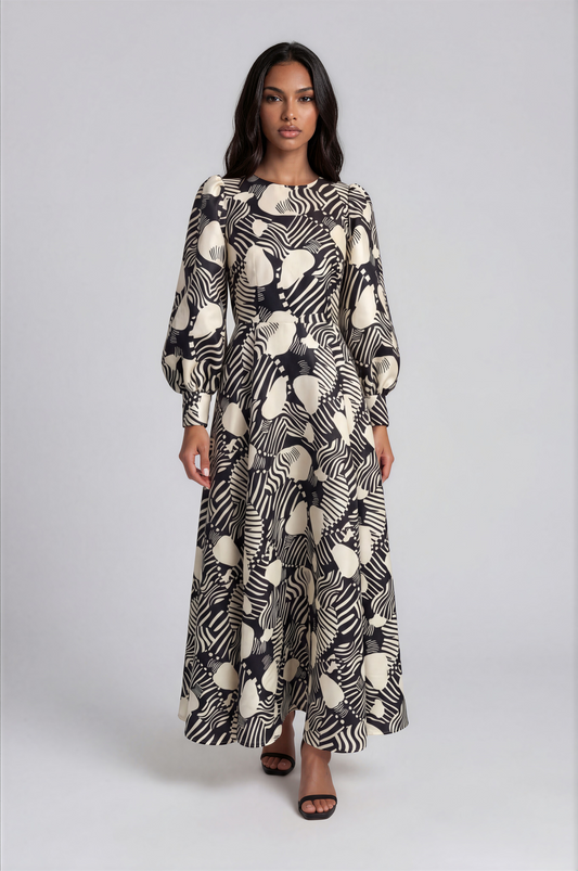 Tally Taylor black and white floral brocade maxi dress featuring bishop sleeves, a round neckline, and a decorative brooch.