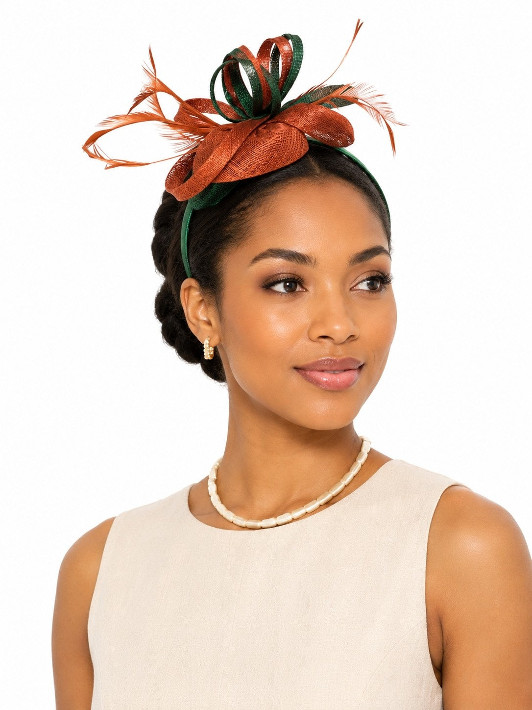 Model wearing the Tally Taylor Two-Tone Feather Fascinator Headband in deep emerald, featuring sculptural loops and feather accents, style H5749.