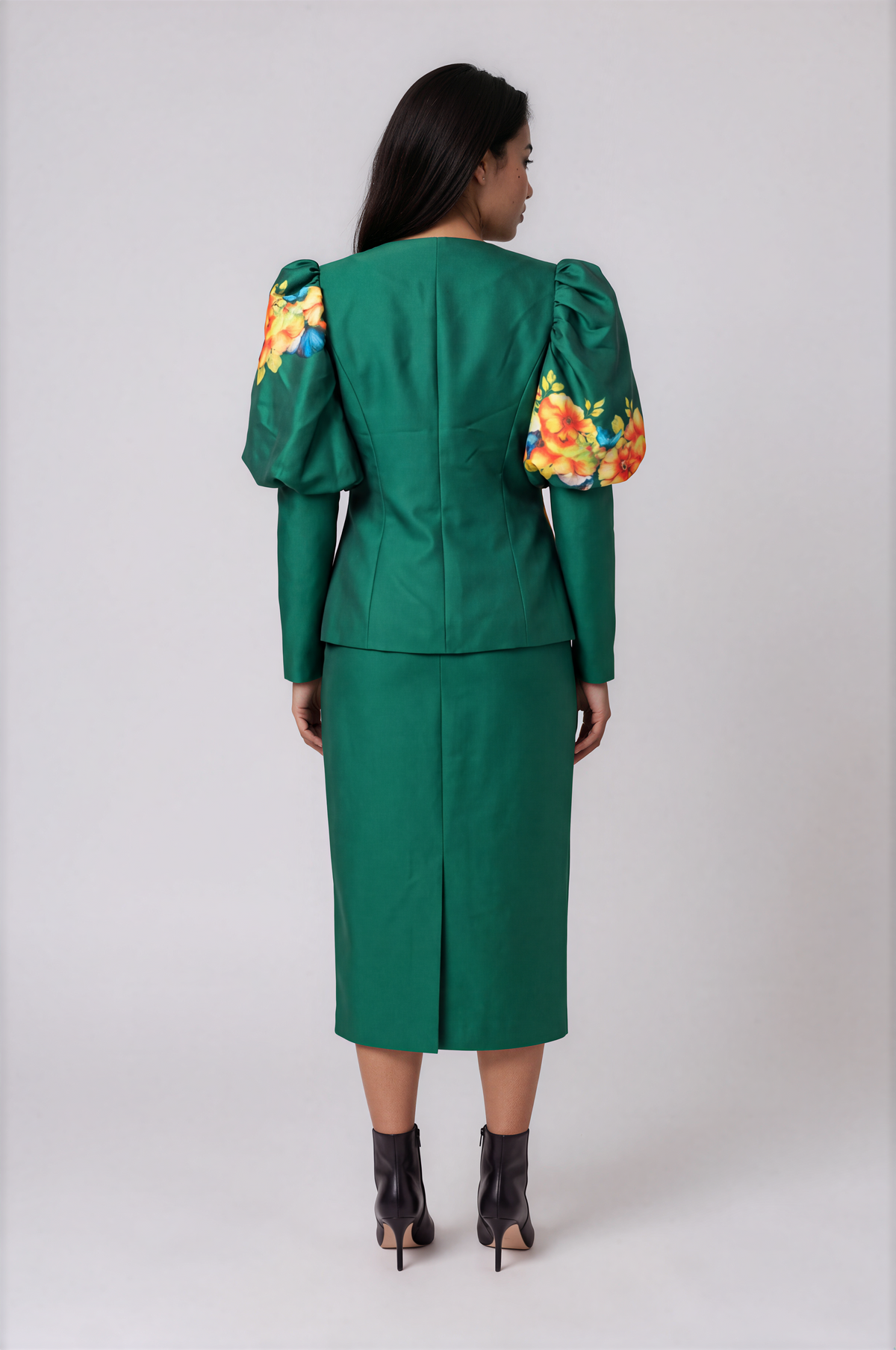 Back view of the emerald green Tally Taylor Floral Puff Sleeve Jacket & Midi Skirt Set – T5749 on a mannequin, featuring floral puff sleeves and a skirt back slit