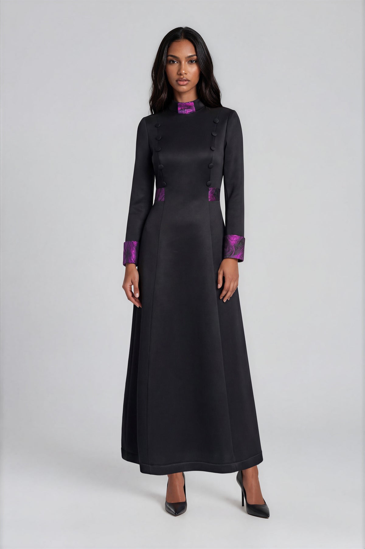 Tally Taylor plus size black women's clergy robe featuring regal purple trim at the collar, cuffs, and waist with decorative button accents and a flattering A-line silhouette.