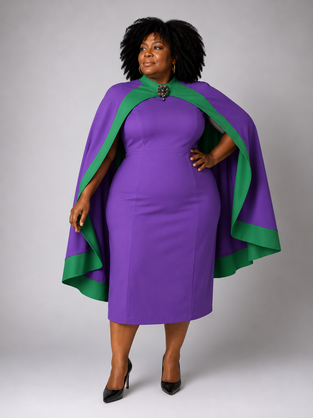 Front view of a plus-size model wearing the Tally Taylor Plus Size Cape Sheath Dress - U0617W in purple with green trim and a jeweled brooch