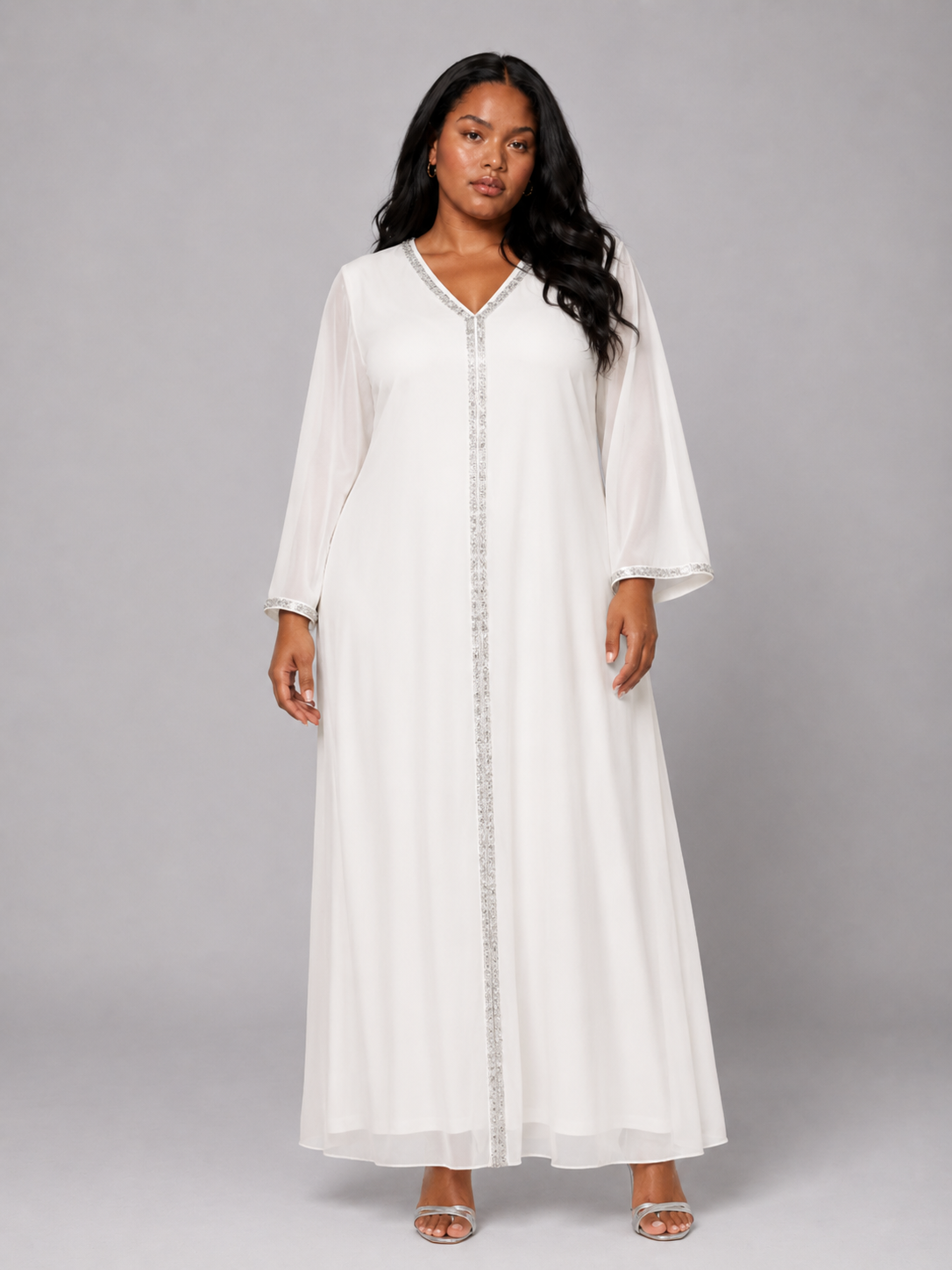 Plus size model wearing the Tally Taylor Crystal Trim Chiffon Caftan Dress in white, featuring shimmering crystal trim and flowing long sleeves, style U0527W