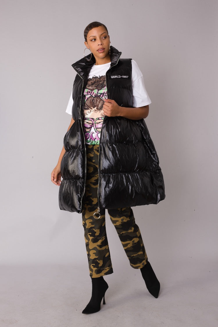 Three-quarter side view of black tiered puffer vest — For Her NYC.