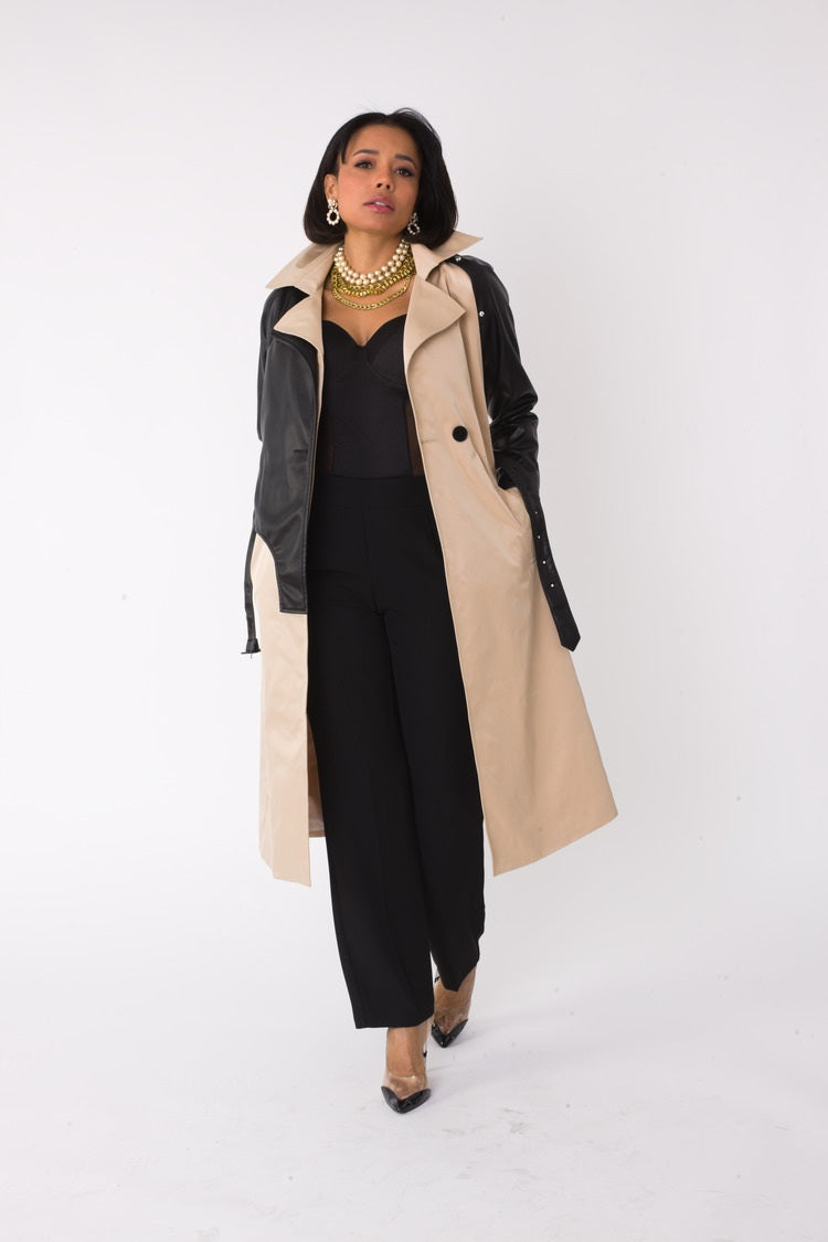 Model wearing the khaki and black two tone leather sleeve trench coat walking forward, highlighting classic trench silhouette with modern leather sleeves by For Her NYC