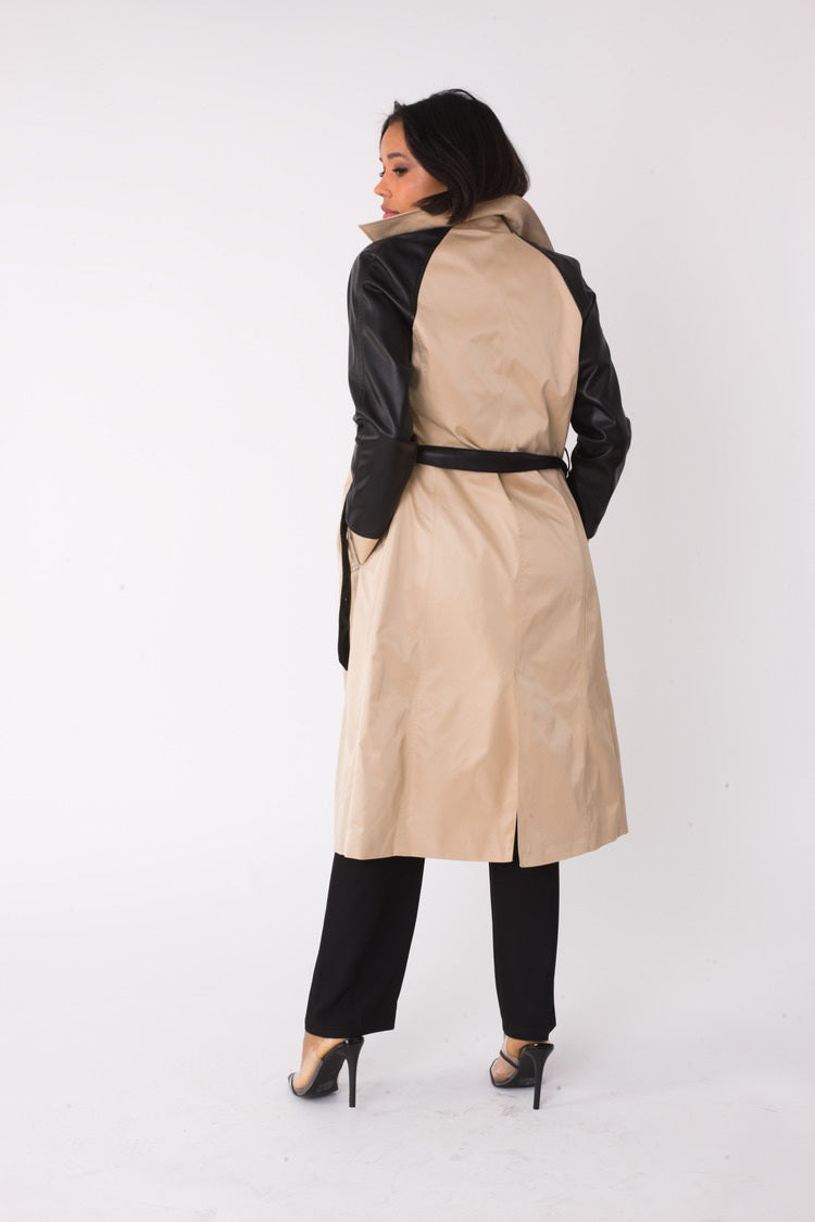 Three quarter angled view of model wearing the khaki and black two tone leather sleeve trench coat emphasizing contrast sleeves and tailored fit by For Her NYC