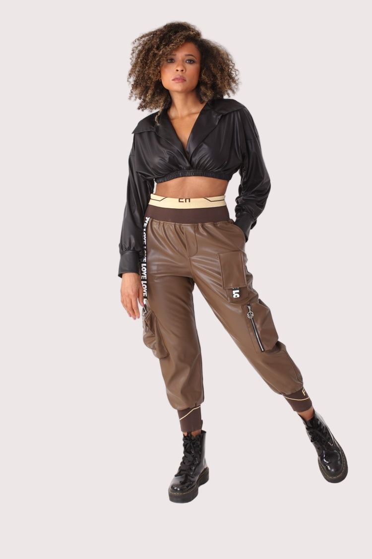 Model walking in brown vegan leather cargo joggers with utility pockets and ankle cuffs, fashion-forward athleisure styling, For Her NYC